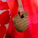 Vrouw met fleurige rode jurk houdt rieten tas vast in hand - strooien tassen