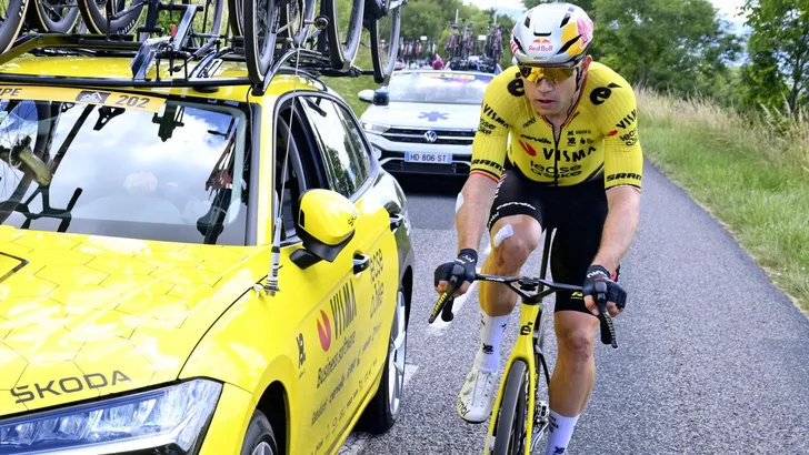 Wout van Aert naast de ploegleiderswagen vlak voor de doktersauto.