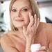 Vrouw brengt serum aan op haar gezicht voor een stralende, verzorgde huid.