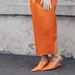 Streetstyle-foto van vrouw met oranje rok en matchende oranje pumps. – Oranje must-haves voor Koningsdag.