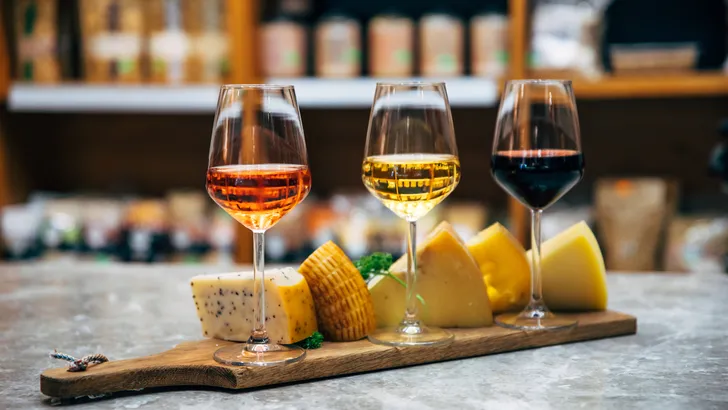 Wine bottles, glasses and cheese in restaurant