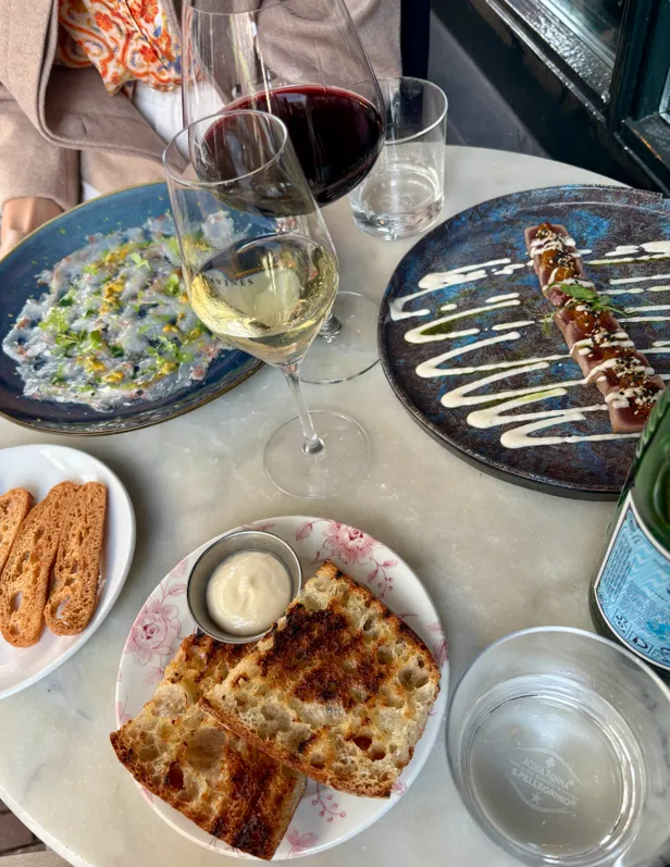 Tafel met wijnglazen en tapasgerechten.