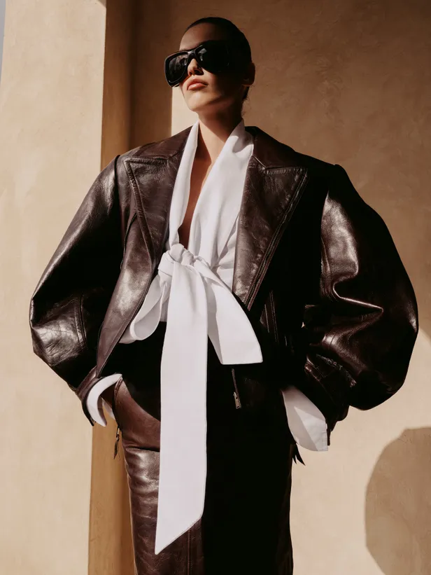 Jasje en rok van leer, bloes van poplin katoen, bril: Saint Laurent by Anthony Vaccarello 