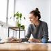 Weegschaal vrouw kijkt blij naar haar laptop terwijl ze werkt
