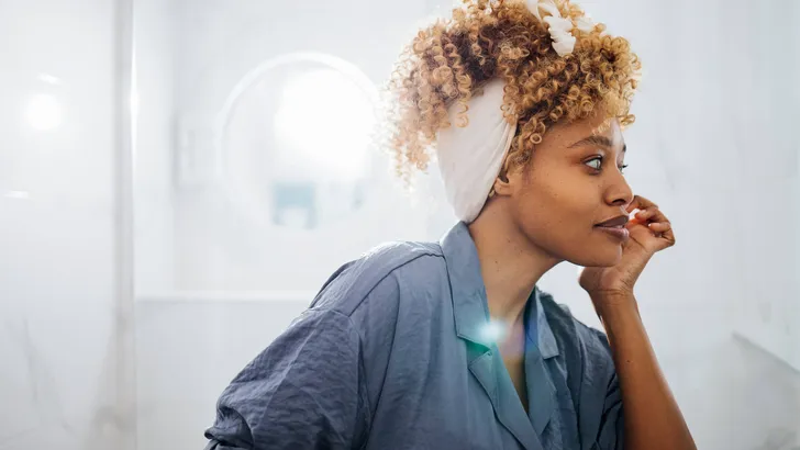 Beautiful Woman Looking at Herself in the   Bathroom Mirror
