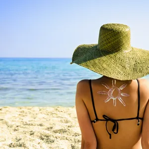 Foto van vrouw met zonnebrandcrème op strand. – Perfecte zonbescherming bij jouw huid kiezen
