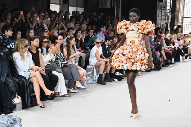Model draagt een kleurrijke bloemenjurk van modeontwerper Marina Hoermanseder tijdens Berlijn fashion week.