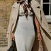 Vrouw straalt in stijlvolle jurk tijdens fashion week momentje.