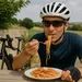 Wielrenner in fietskleding eet een bord spaghetti aan een buitentafel, met zijn racefiets op de achtergrond.