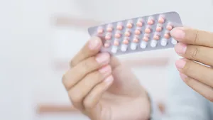 Woman hands opening birth control pills in hand. Eating Contraceptive Pill.