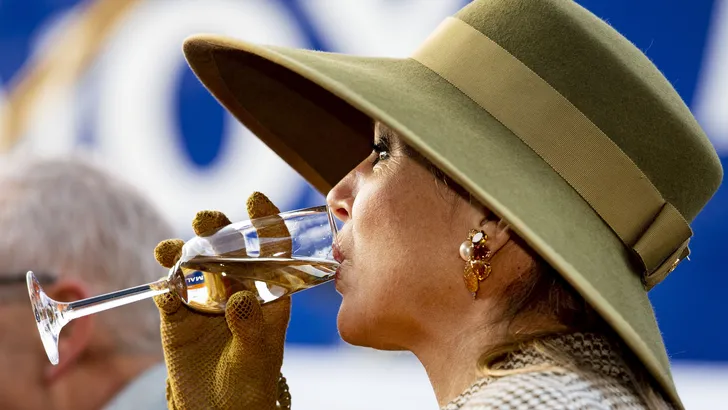 10x koningin Máxima met een glaasje wijn in haar hand