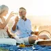 Foto van stel dat samen wijn aan het drinken is op een strand. – Stellen die samen drinken zijn gelukkiger en leven langer volgens onderzoek.