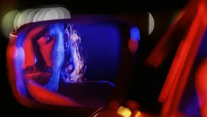 Man die in autospiegel kijkt