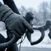 Close-up van wielrenner met dikke winterhandschoenen die elektronisch schakelt op een racefiets tijdens een koude winterrit.