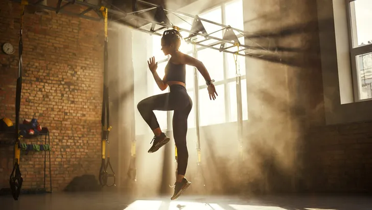 Always in good shape Full length of athletic woman in black sport clothing exercising in professional gym.