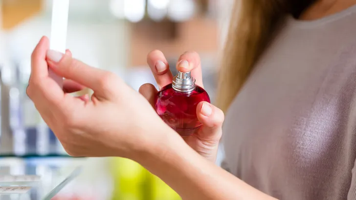 Junge Frau kauft Parfum in Parfümerie