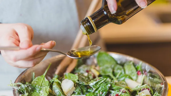 Closeup of hands pouring olive or sunflower oil