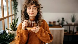 Portrait of young beautiful woman having a tea in her apartment