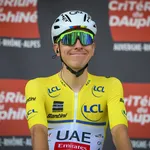tadej pogacar voor een bord met criterium du dauphiné