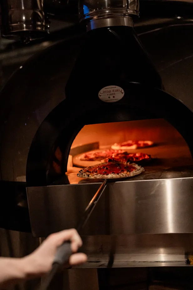 De houtgestookte oven is het middelpunt van het restaurant 