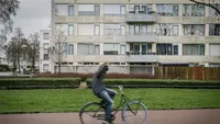 Sfeerbeeld van de Utrechtse Wijk Overvecht; een langsrijdende fietser steekt zijn middelvinger op