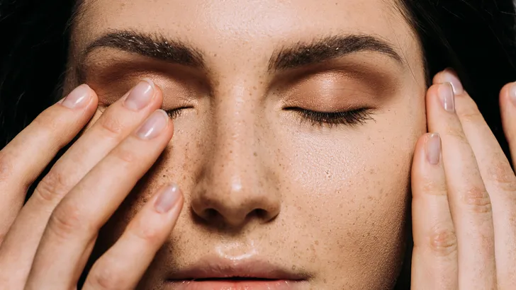Close-up van vrouw die skincare aanbrengt op haar huid.