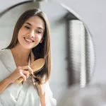 Beauty Routine. Pretty Woman Combing Her Beautiful Hair With Brush