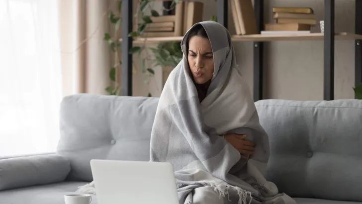 Sick woman feel cold at home covered with blanket