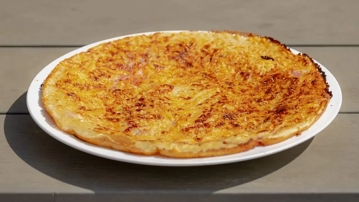 Ham and cheese Pannekoek on wooden table, Dutch pancake is a thin pancake that can be served sweet or savory, There are so many ways to enjoy this easy treat for breakfast or a fun snack.