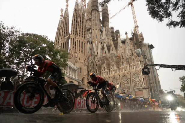 Bahrain bezig aan een ploegentijdrit op natte wegen in Barcelona, vlak voor de Sagrada Familia.