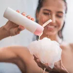 Glad female pressing liquid onto bath sponge