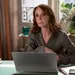 Sylvie in Emily in Paris achter haar laptop - salaris