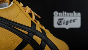 Tokyo, Japan, 23 March 2021,The yellow black Tai Chi Reb Onitsuka Tiger sneaker sport footwear is displayed on the black display shelf in the Onitsuka Tiger shop in Shinjuku branch during summer sales