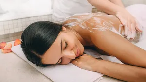 Hammam. Masseur applying foam to a beautiful woman on the body. Woman relaxed in a hammam