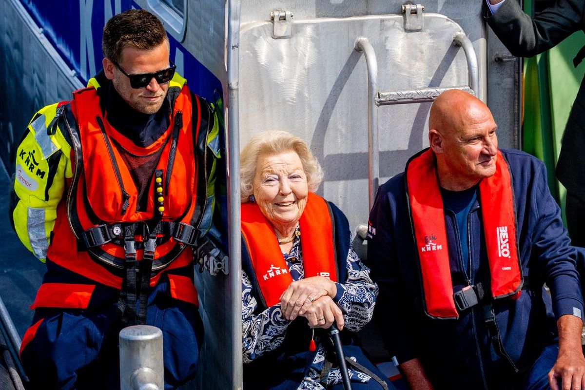 Prinses Beatrix racet met glimlach over het water tijdens bezoek aan reddingstation KNRM