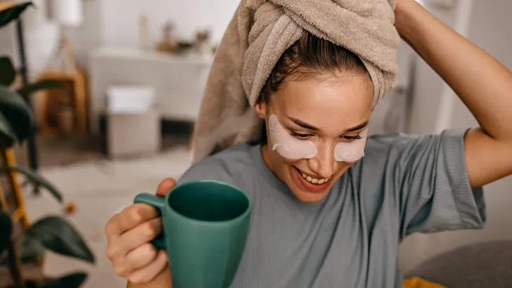 Woman with medical eye patch drinking coffee