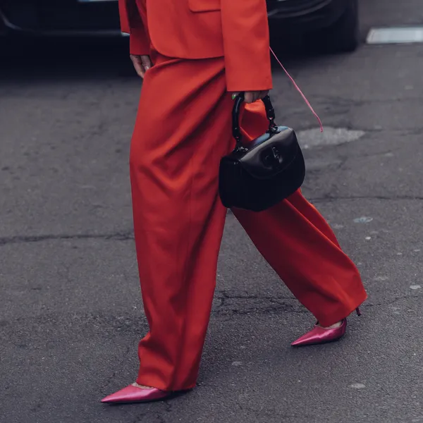 De Weekendtips van Beau Monde, week 12 2025. – Streetstyle-foto van vrouw in rood oversized broekpak.