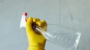 Foto van hand met sprayfles schoonmaakmiddel bij voorjaarsschoonmaak