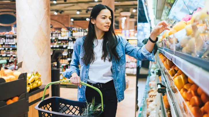 Young woman doing grocery shopping in supermarket