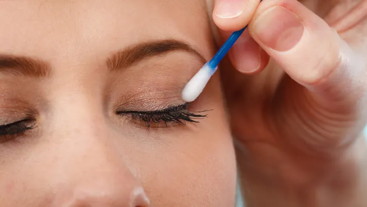 Woman getting her makeup done with cotton buds