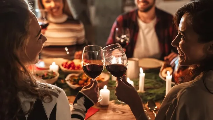 Photo of nice joyful people drinking wine and having Christmas dinner