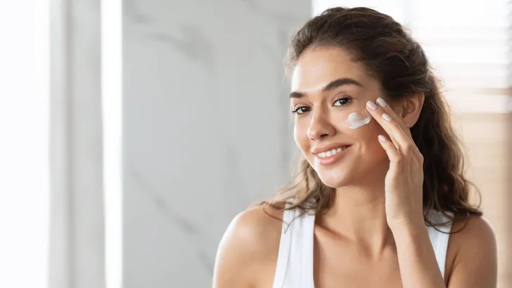 Een vrouw die retinol aanbrengt op haar gezicht