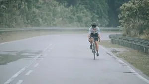 Asian Chinese professional cyclist athlete sportsman cycling in the rain in rural area