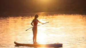vrouw op supboard zonsondergang