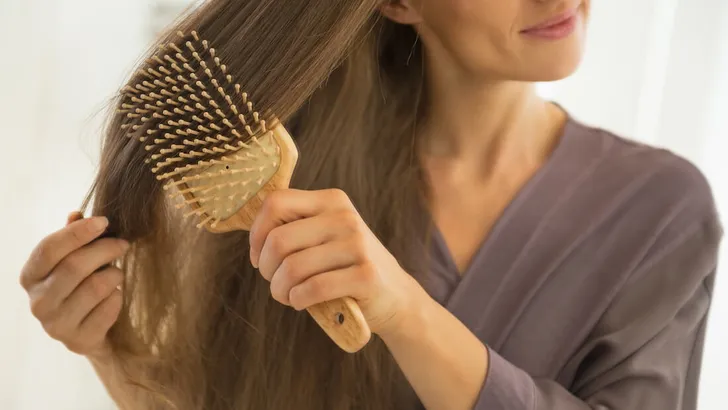 Closeup on young woman combing hair