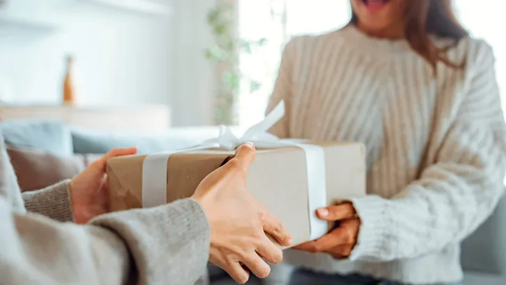 Excited asian woman getting surprise gift from her girlfriend at home. Gives a gift, birthday gift, New year day celebration and congratulation