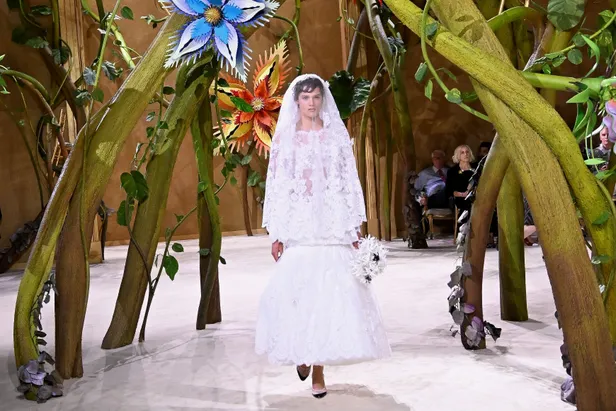 Model in een witte kanten trouwjurk tijdens de show van Chanel tijdens de fashion week in Parijs.