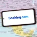 Telefoon met booking.com logo op een kaart van Noord-Amerika