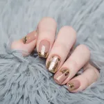 beige Nude manicure with gold lace pattern on a gray background