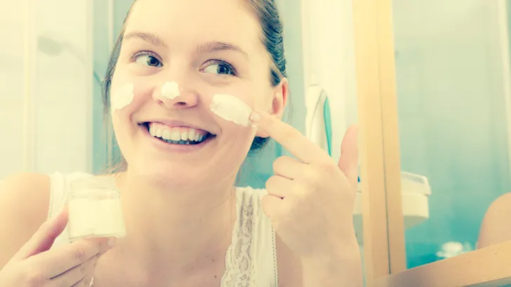 vrouw met creme voor spiegel